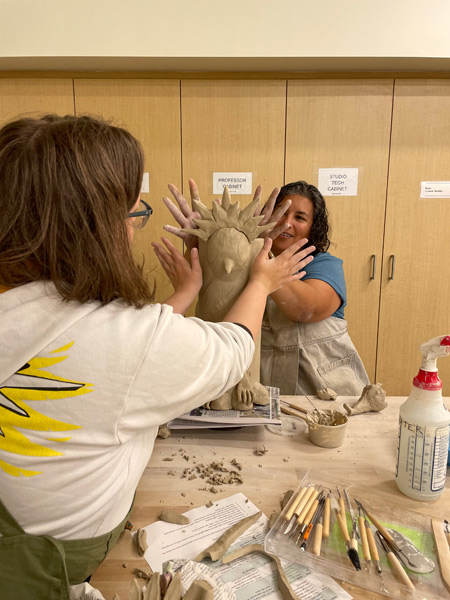 12_students-smiling-and-shaping-the-clay